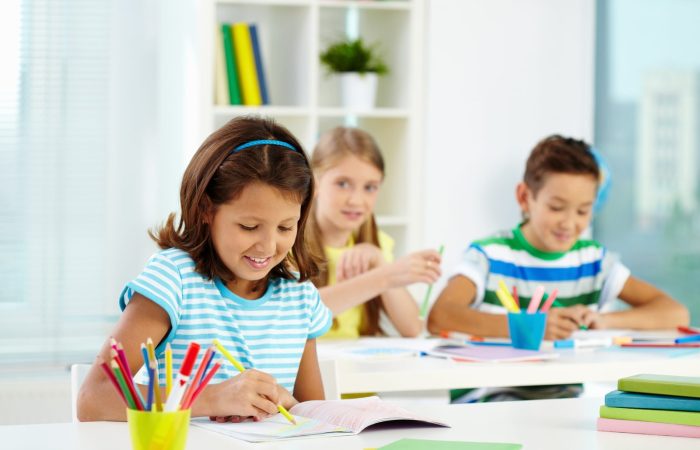 little-girl-drawing-with-classmates-background-scaled.jpg